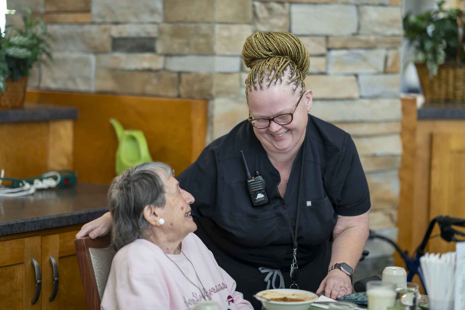 Staff member interacting with a resident in a dining area