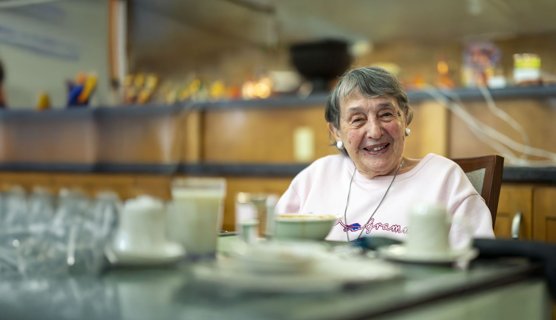 Smiling resident enjoying a meal in the dining room