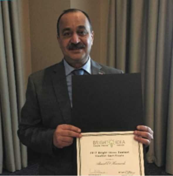 Man holding an award certificate in an indoor setting