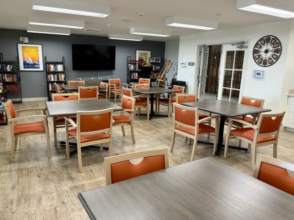 A brightly lit common area with seating and bookshelves
