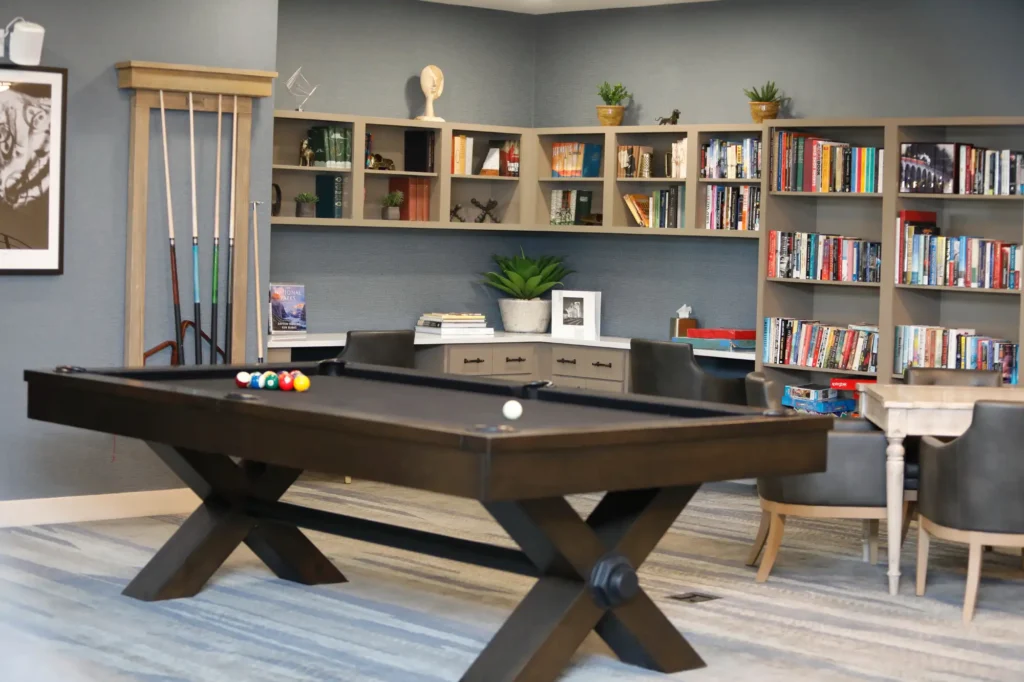 Interior view of a common area with a pool table and bookshelves