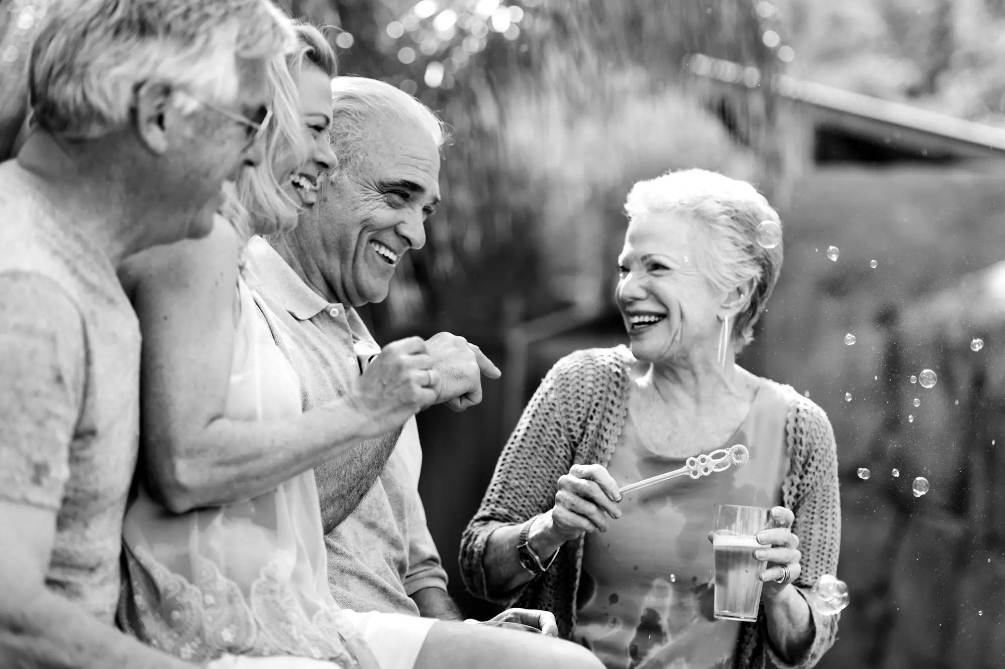Seniors enjoying a playful moment outdoors with bubbles