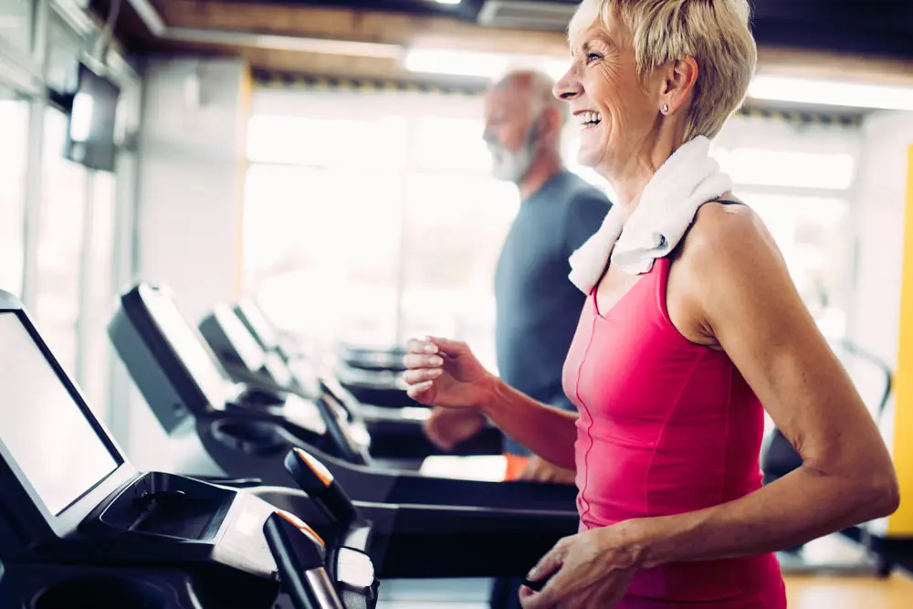 Residents exercising on treadmills in the fitness area