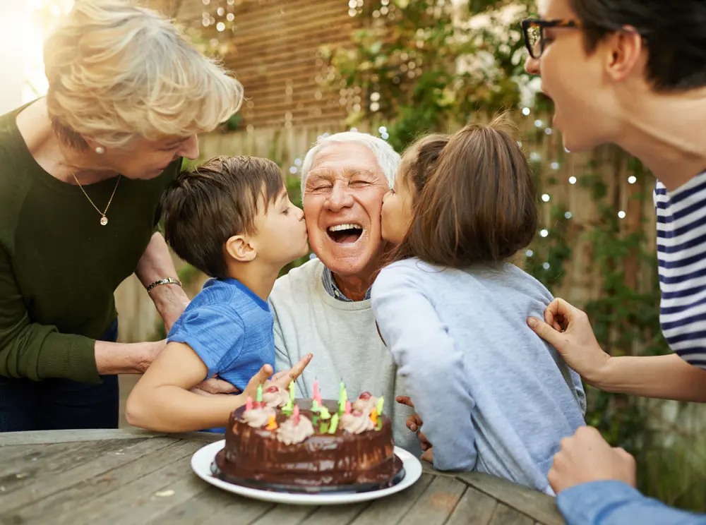 Residents celebrating a birthday with cake outdoors