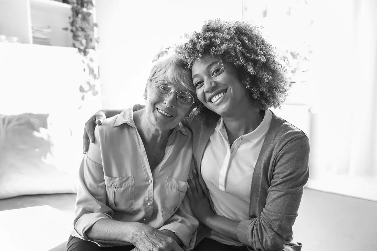 A caregiver and a resident smiling together