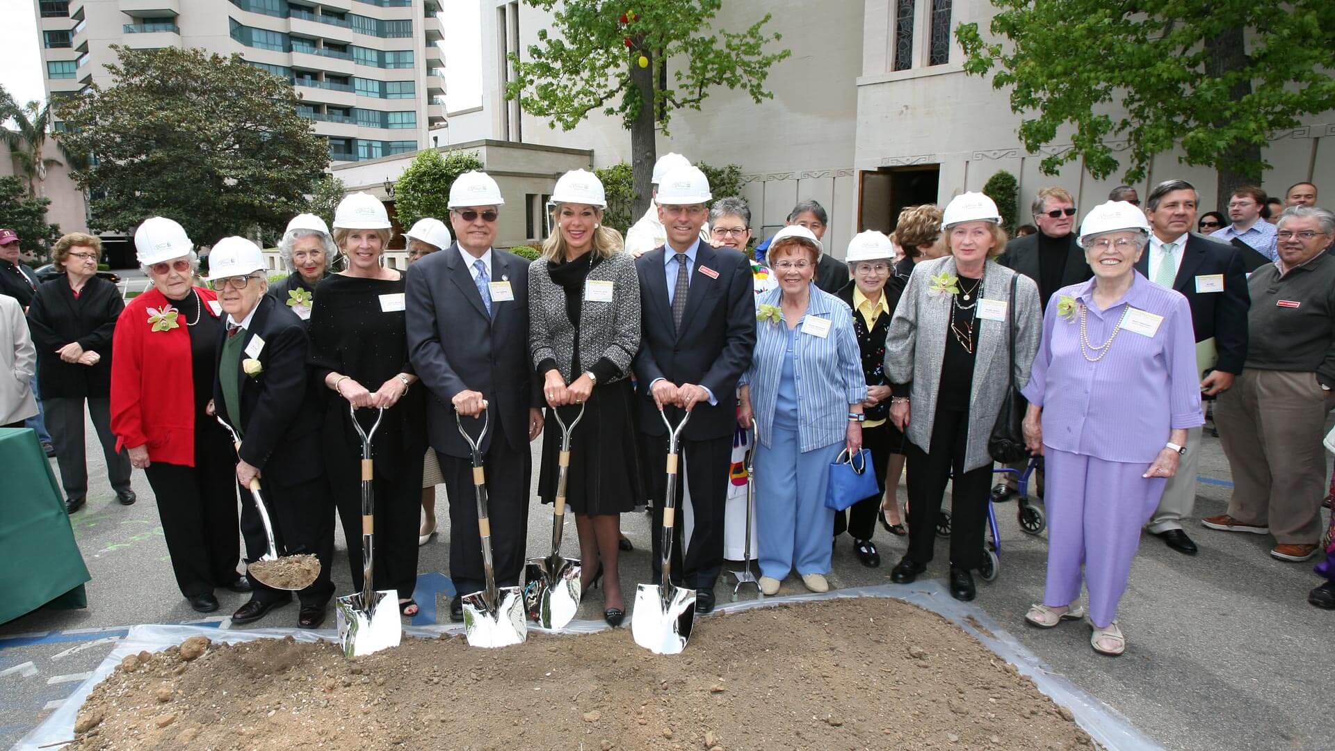 Groundbreaking ceremony with residents and staff wearing hard hats