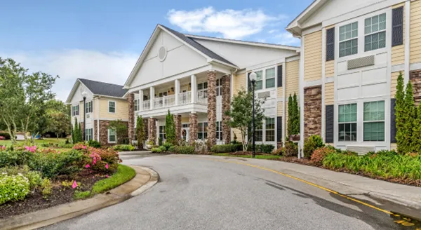 Exterior view of assisted living facility with gardens
