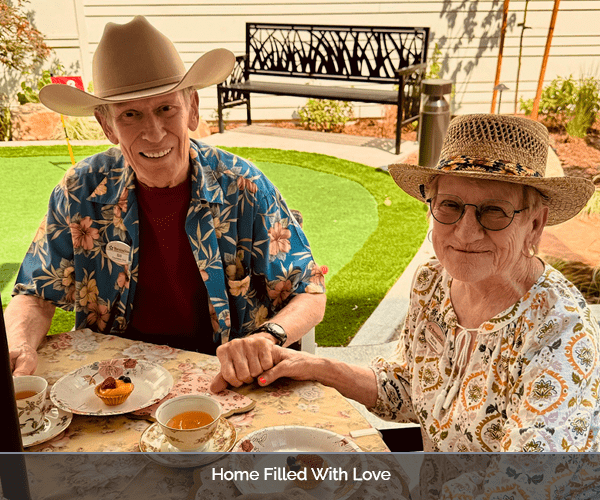 Two residents enjoying tea outdoors at a beautifully set table