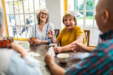 Residents enjoying a card game in a bright interior