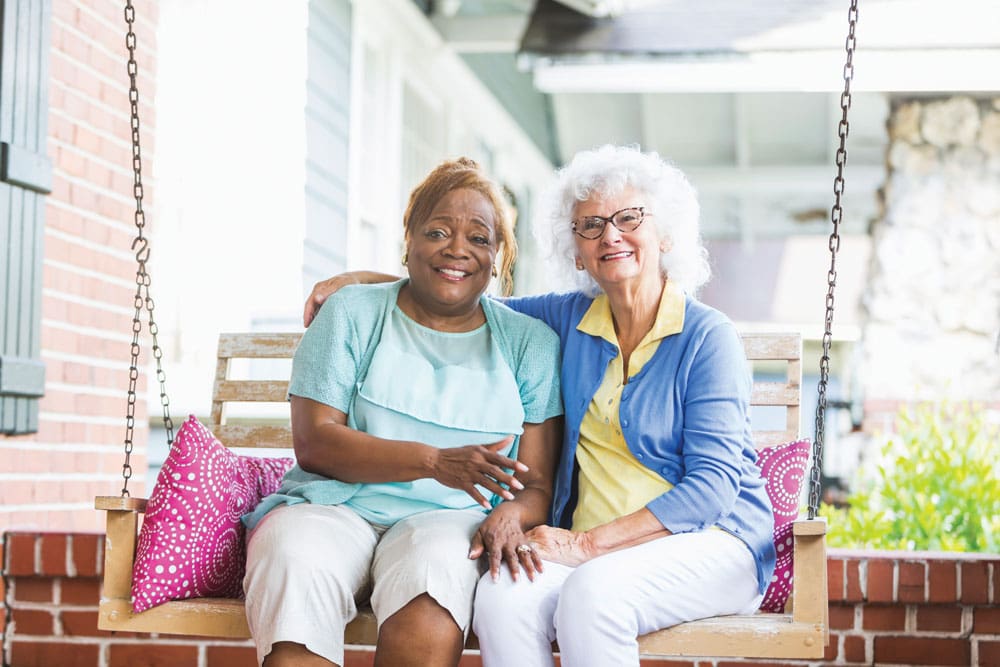 Two residents enjoying time together on a porch swing