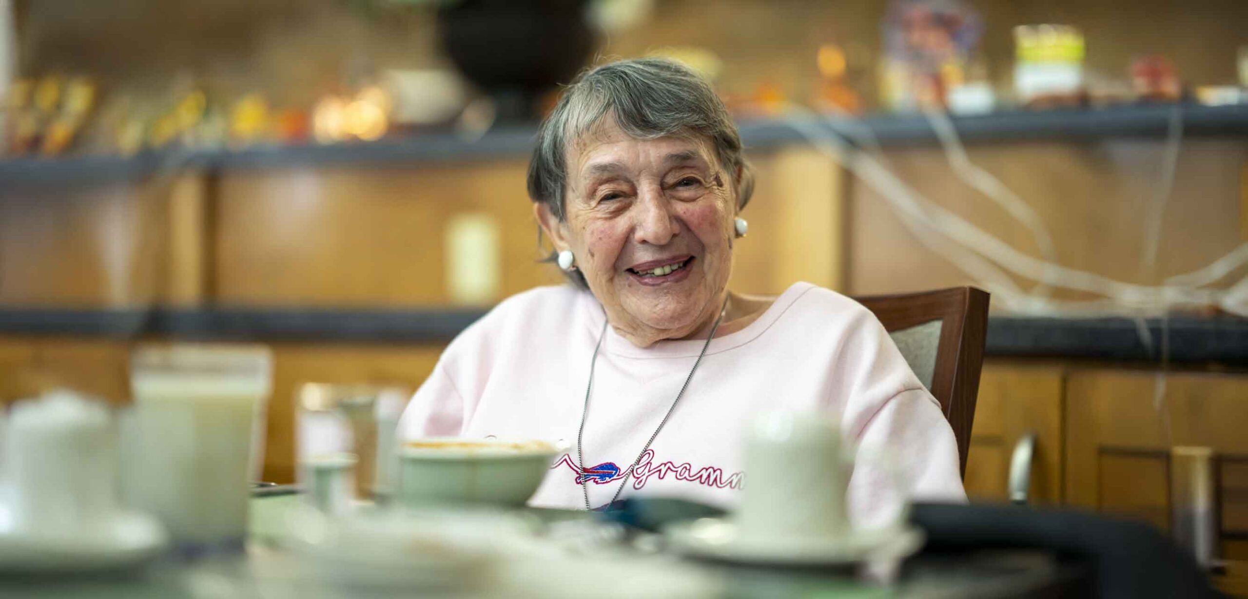 A smiling resident enjoying a meal in the dining area