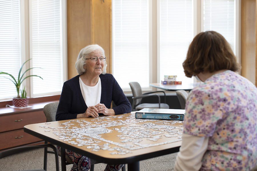 Resident and staff member enjoying a puzzle activity together