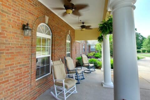 Outdoor seating area with rocking chairs and greenery