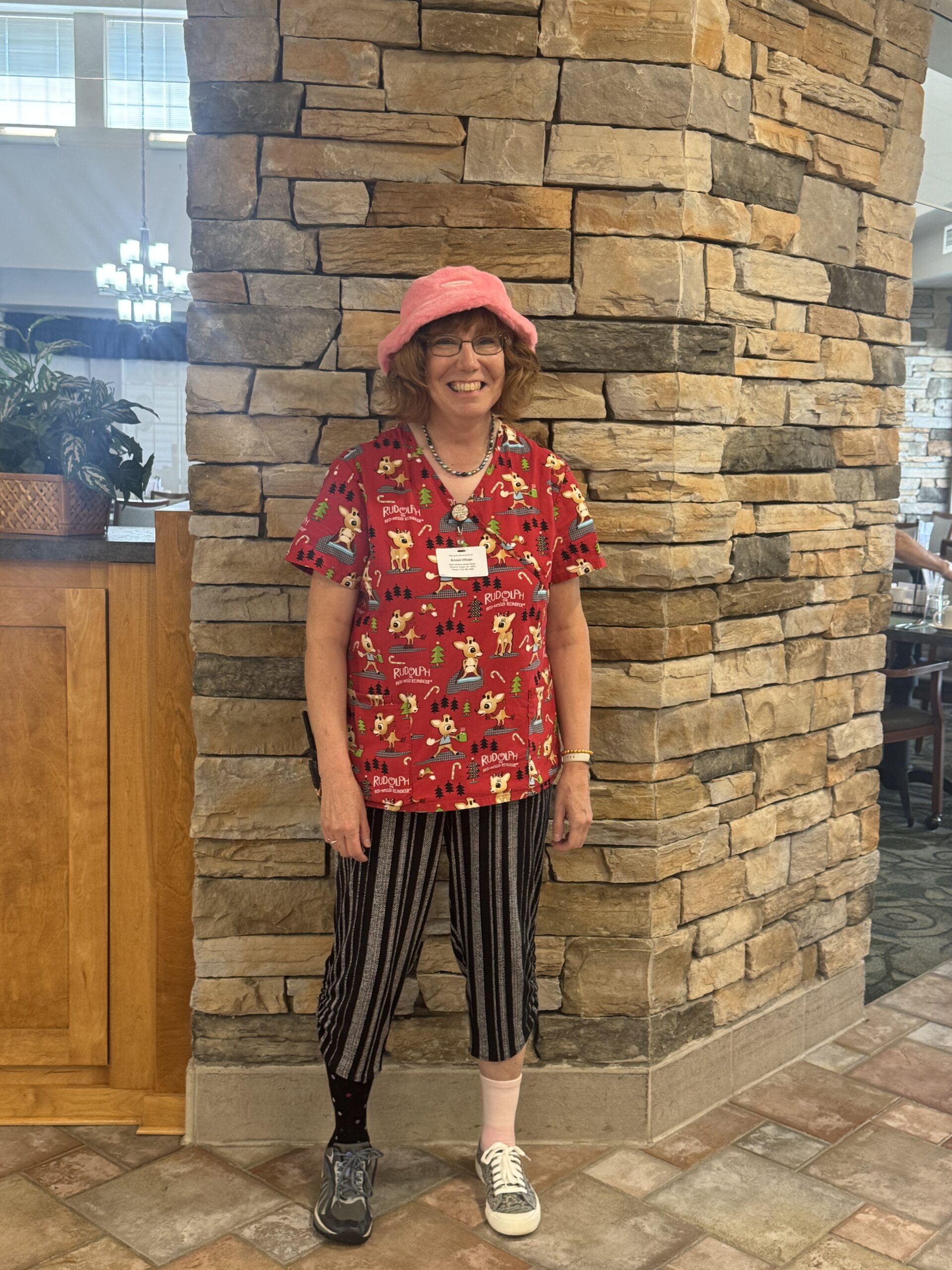 Staff member in colorful attire within facility interior