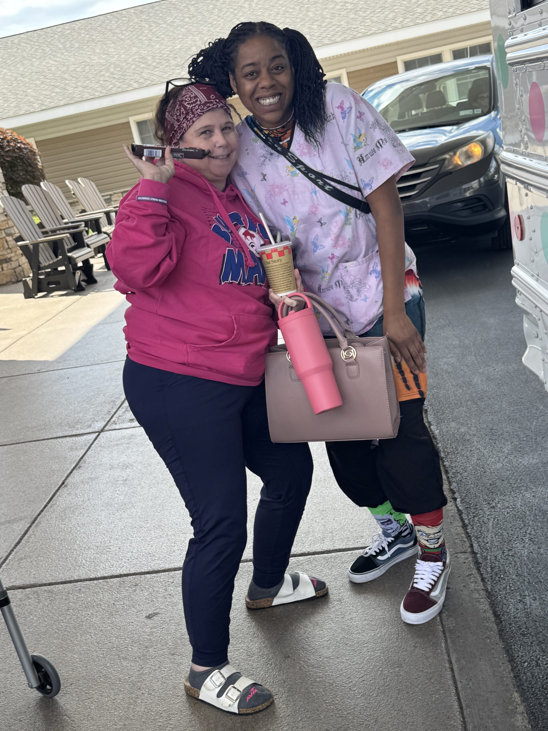 Two residents posing together outside with smiles