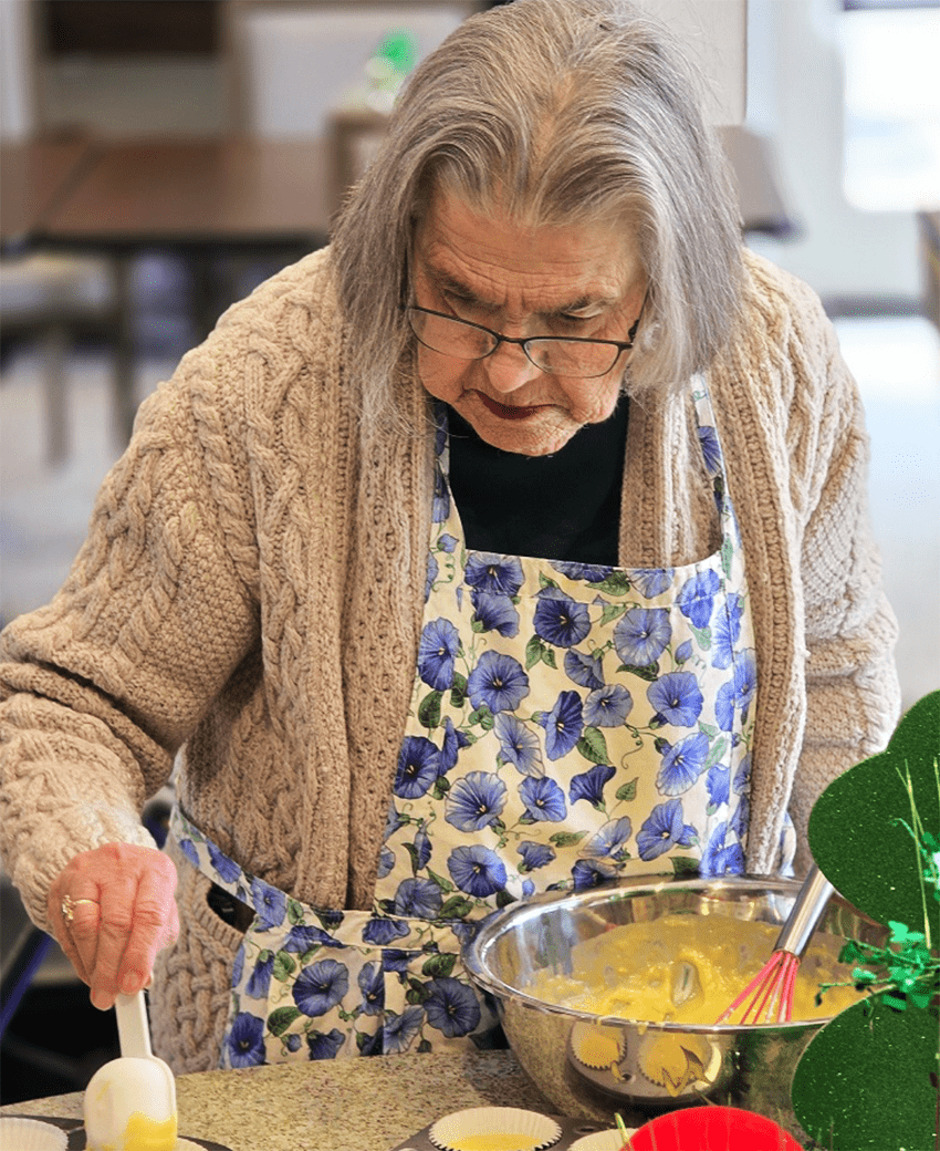 Resident preparing food in a bright kitchen setting