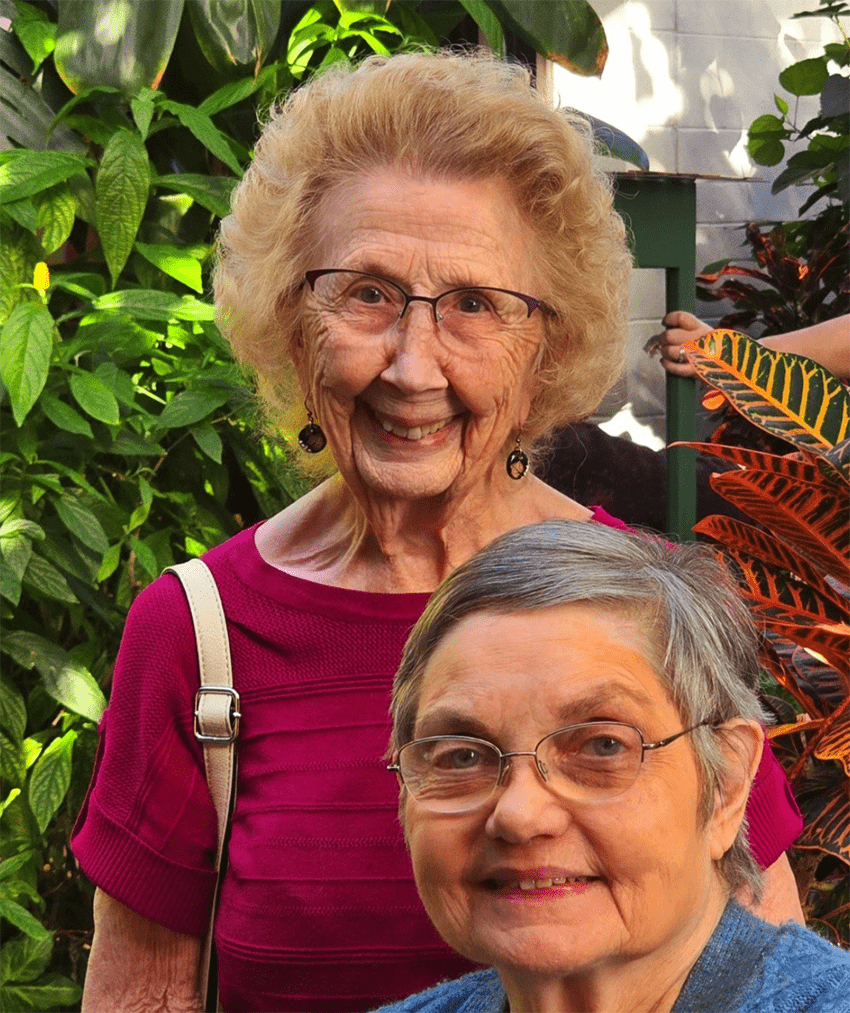 Two smiling residents among greenery