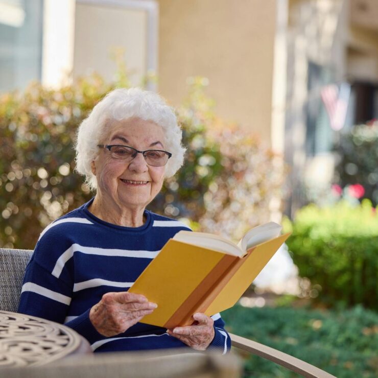 Senior resident reading a book in a garden
