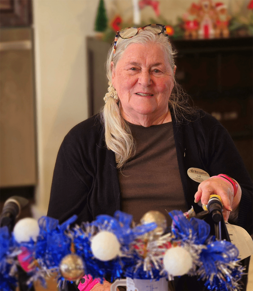 Resident smiling in a common area decorated for a celebration