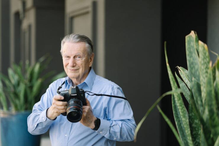 Senior resident holding a camera outdoors