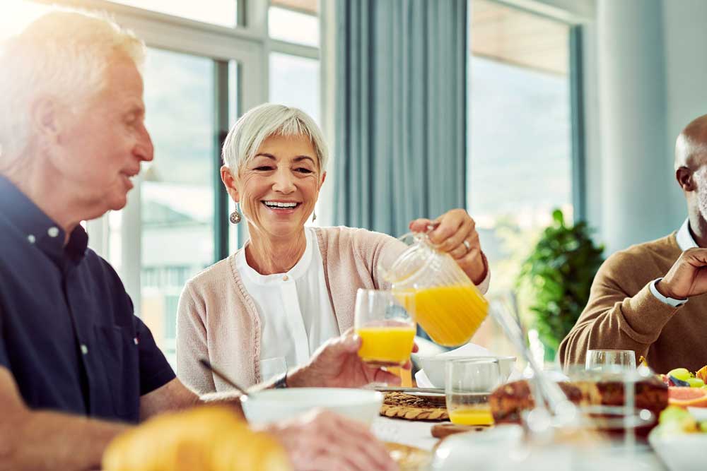 Residents enjoying a meal together with juice