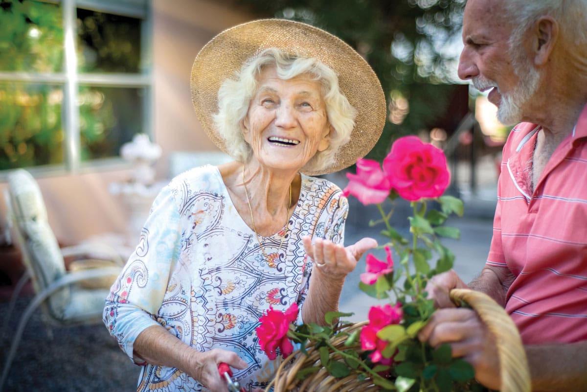 Couple enjoying flowers in a sunny outdoor space