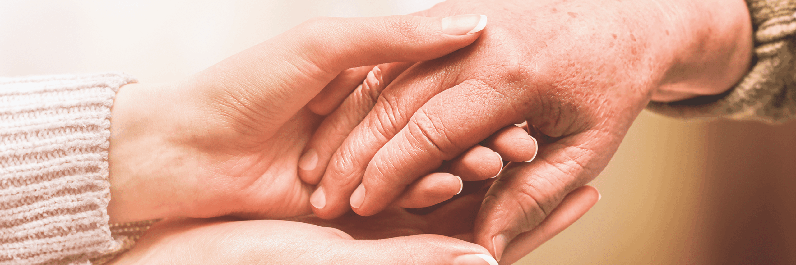 Caring hands holding each other in a warm setting