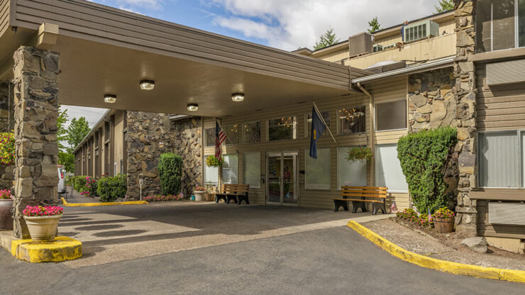 Entrance view of a senior living facility with stone architecture