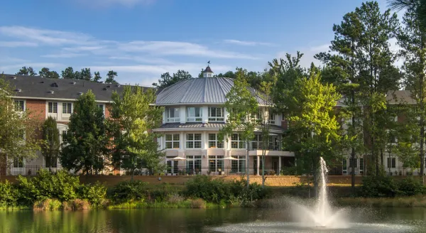 Exterior view of the facility with a pond and fountain