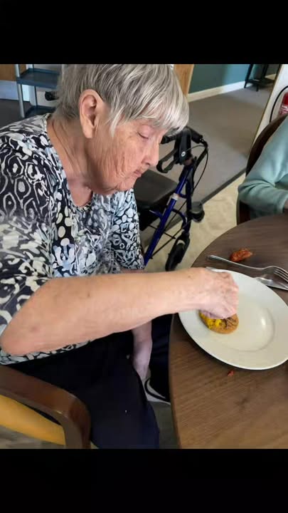 Resident enjoying a meal at a dining table