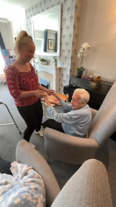 A caregiver assisting a resident in an interior setting