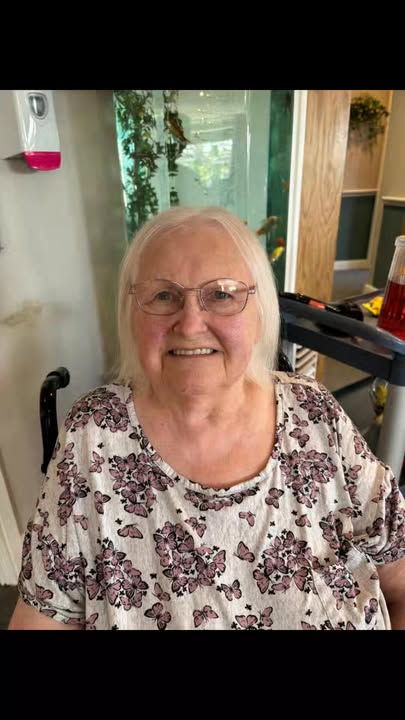 A smiling elderly woman in a care facility