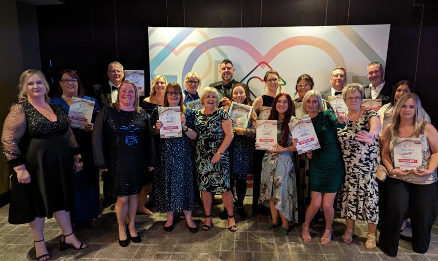 Staff and residents celebrating with awards in a common area
