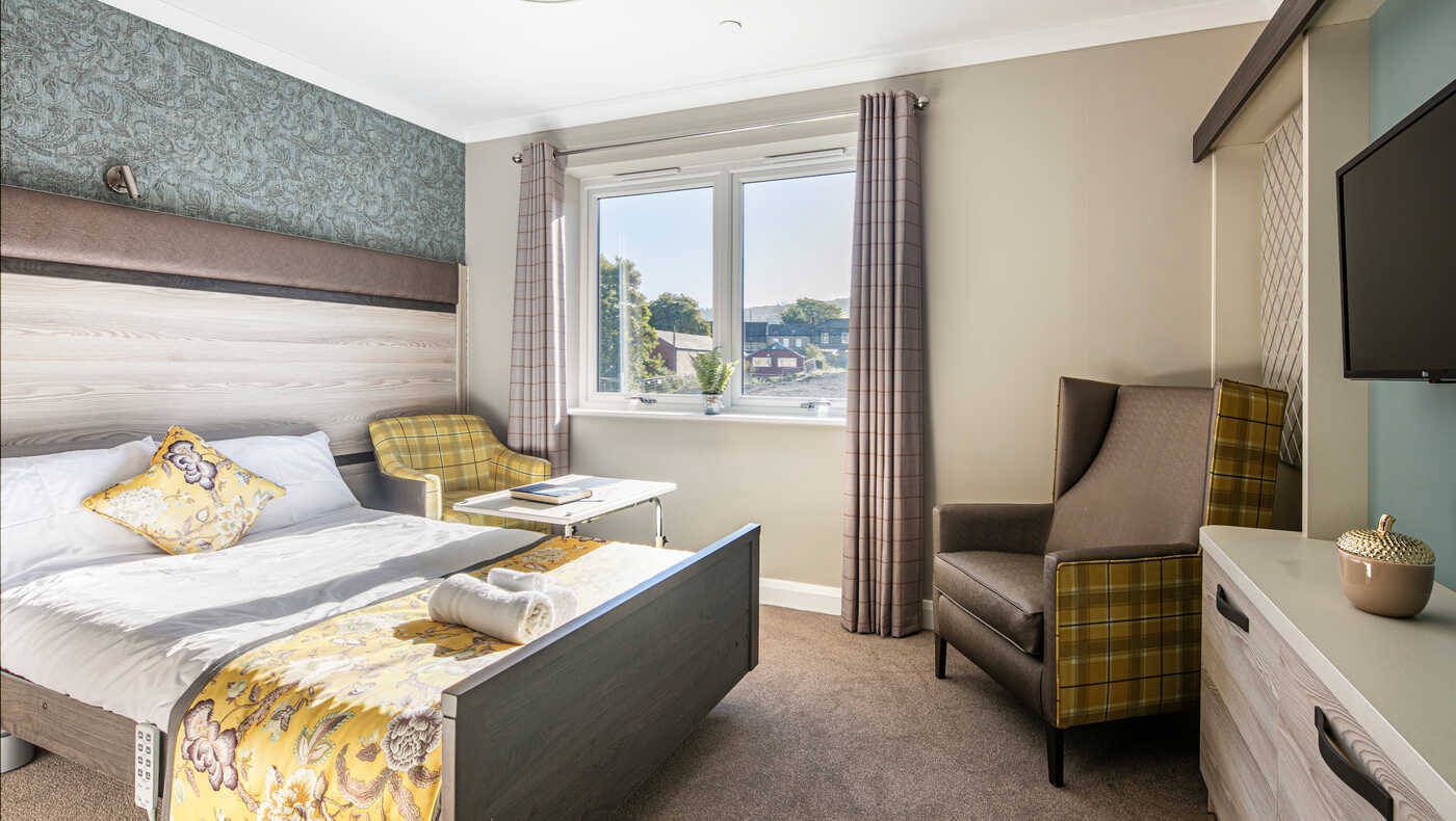 Cozy interior of a resident room with a bed and seating area