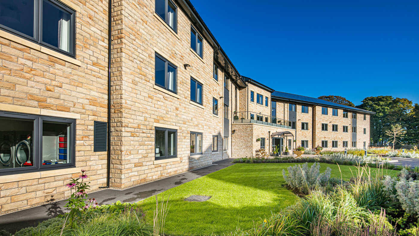 Exterior view of the Mill View facility with landscaped gardens