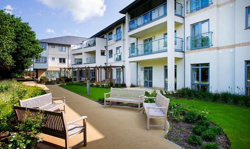 Outdoor seating area with benches and landscaped gardens