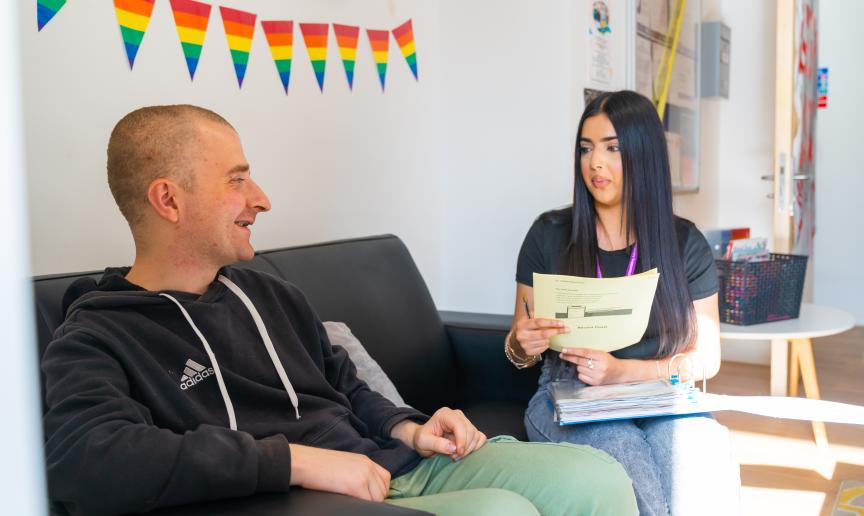 A resident and staff member discussing in a cozy indoor space