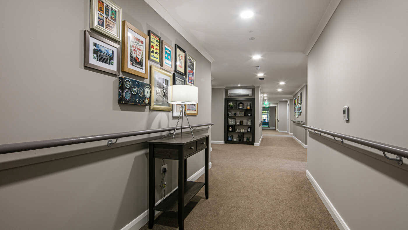 Bright interior hallway with framed art and seating