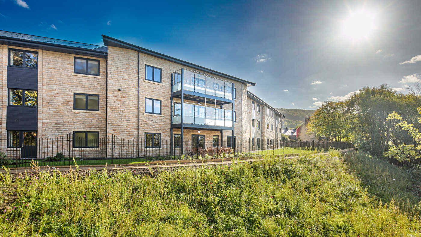 Exterior view of a modern assisted living facility with gardens