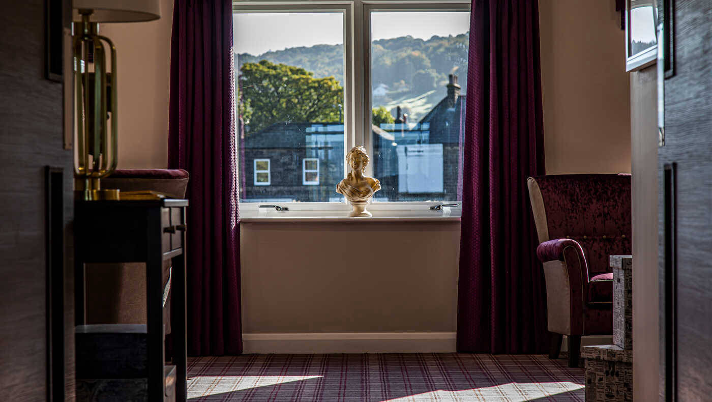 A cozy room with a window and decorative bust