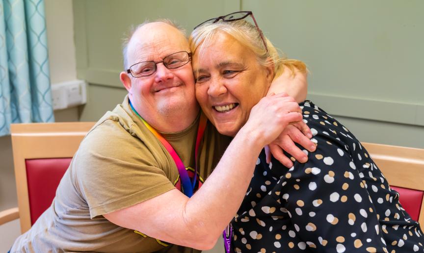Residents sharing a joyful embrace in a common area