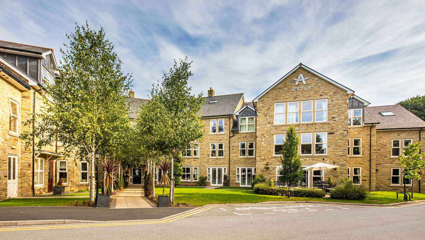 Exterior view of a senior living facility with landscaped area