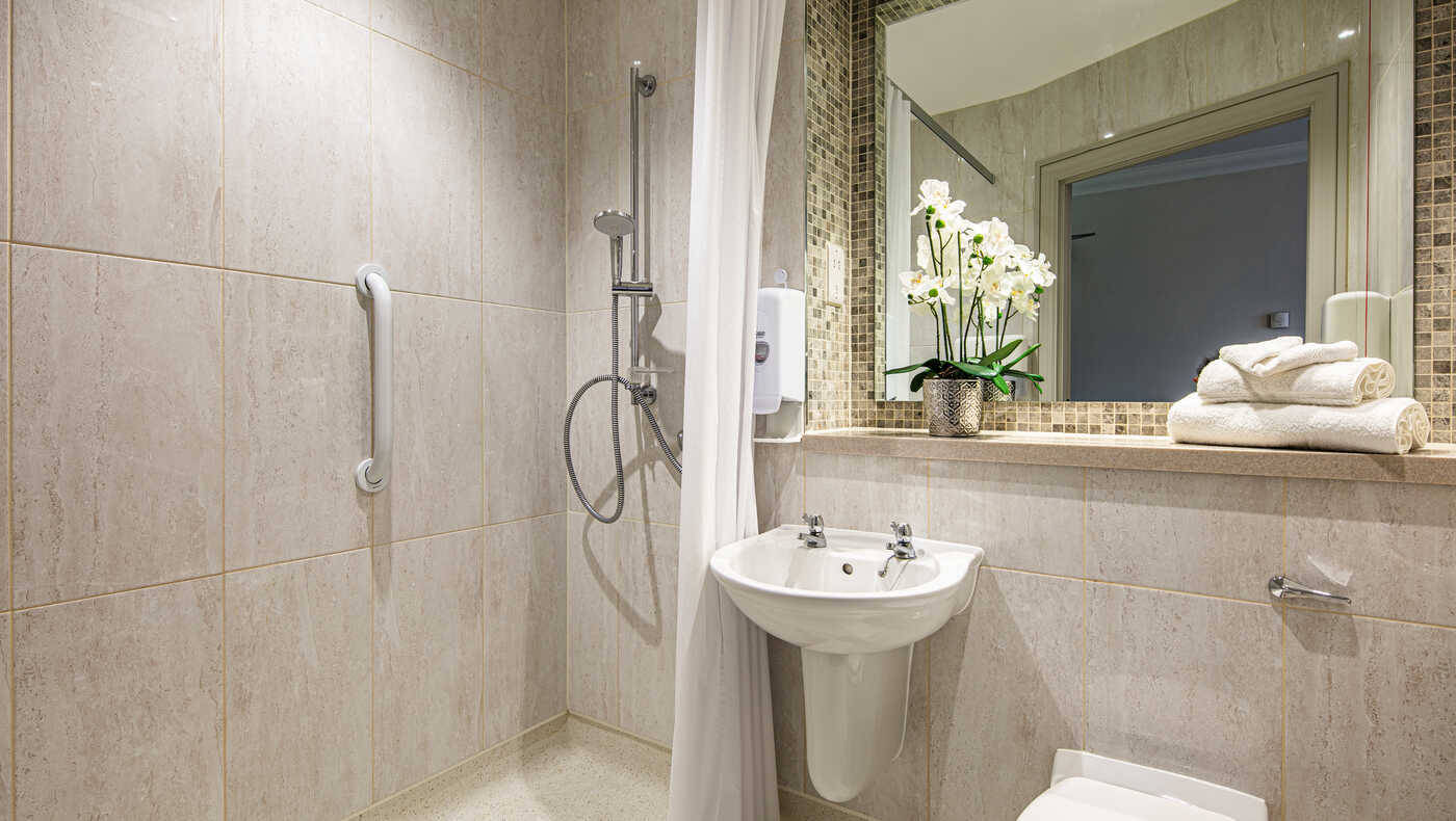 Modern bathroom with grab bars and flowers