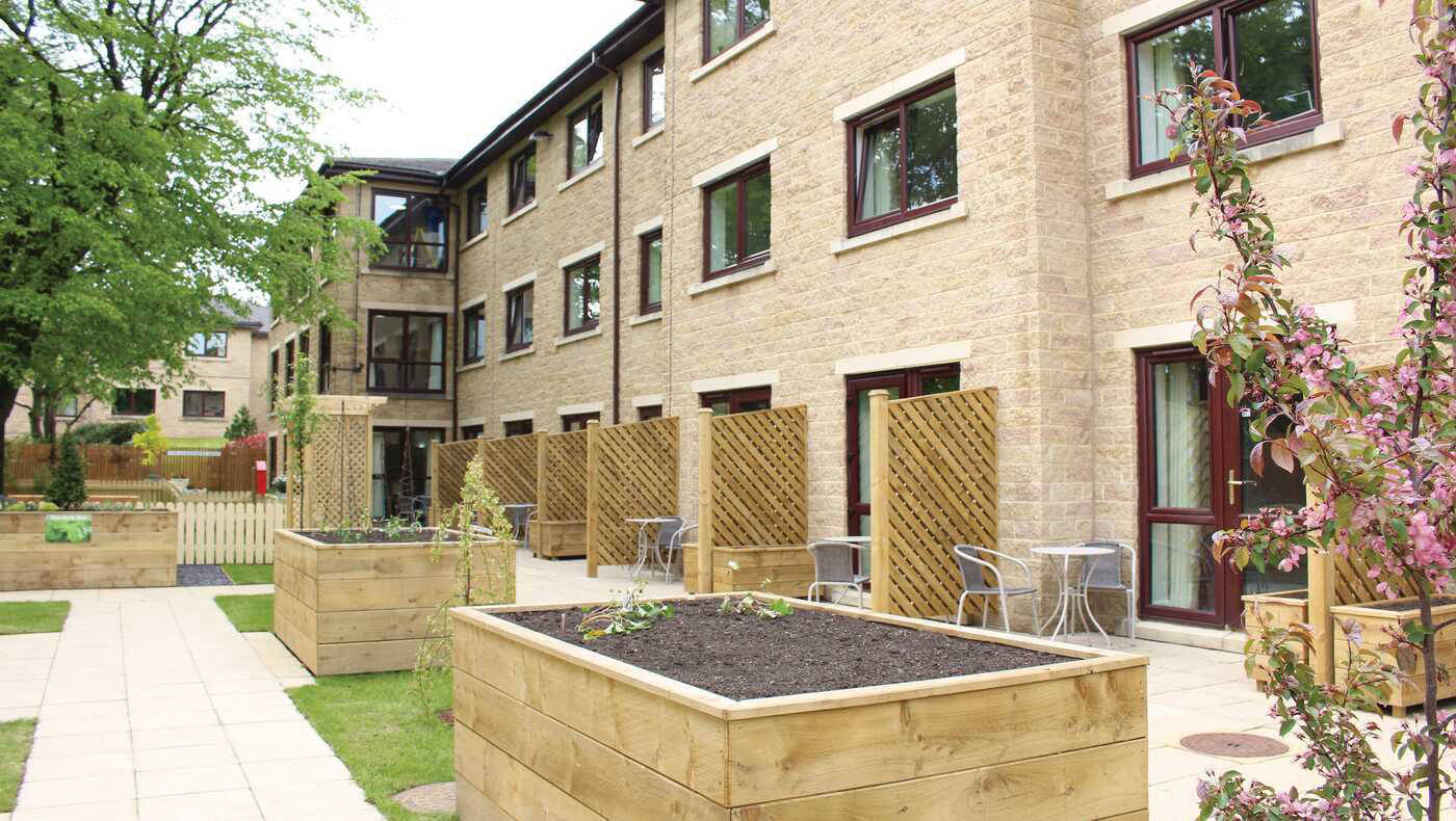 Exterior view of a senior living facility with outdoor seating