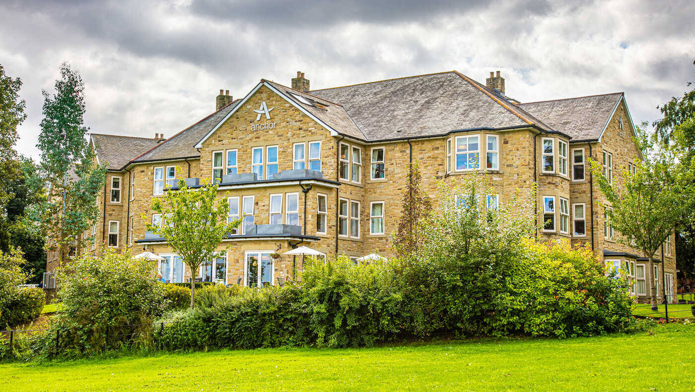 Exterior view of a senior living facility with gardens