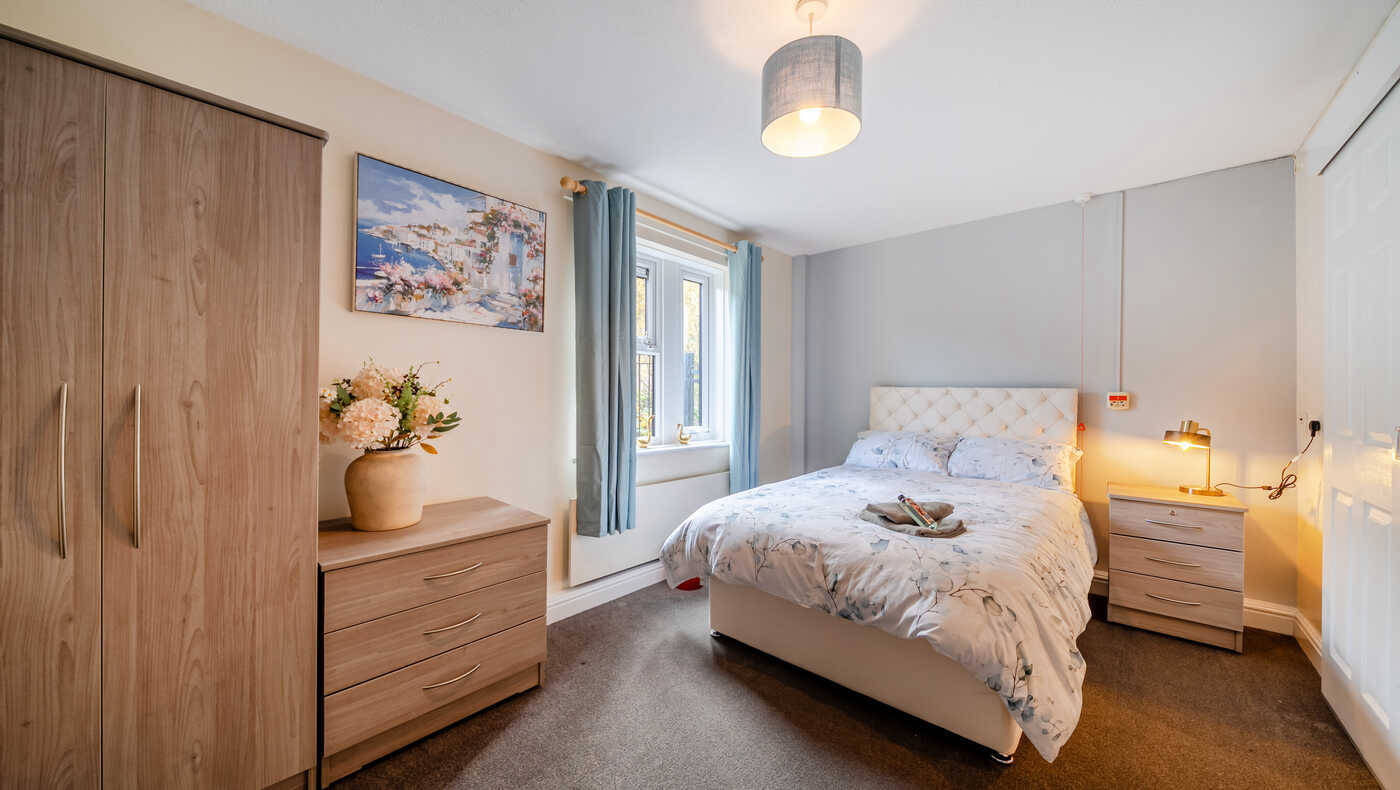 A cozy private bedroom with a bed and storage