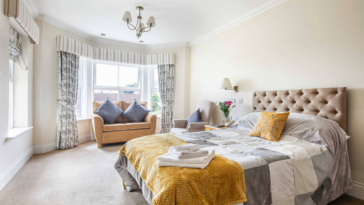 Cozy assisted living room with a large bed and seating area