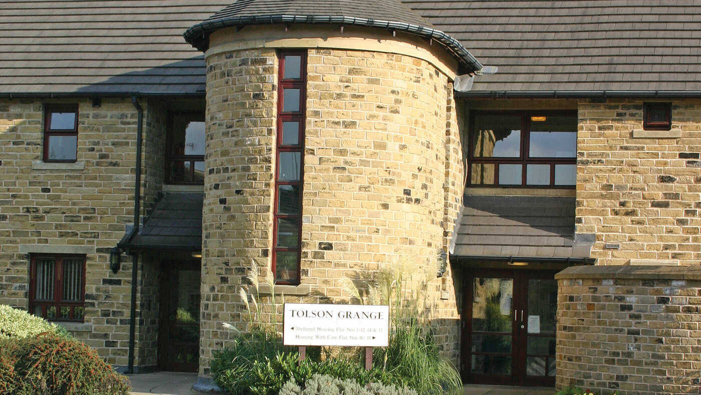 Exterior view of a nursing home entrance with signage