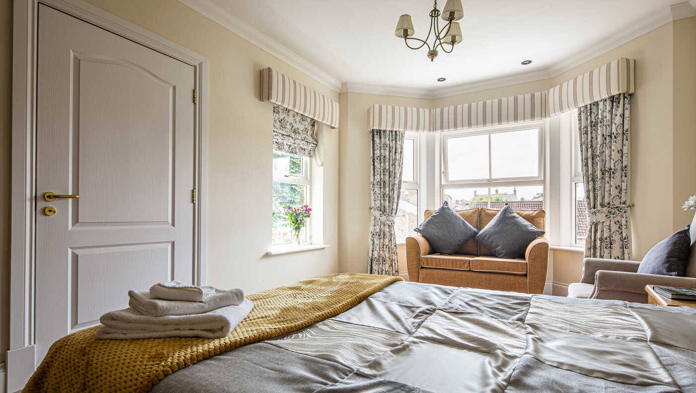 Bright interior view of a resident room with a bed and seating area