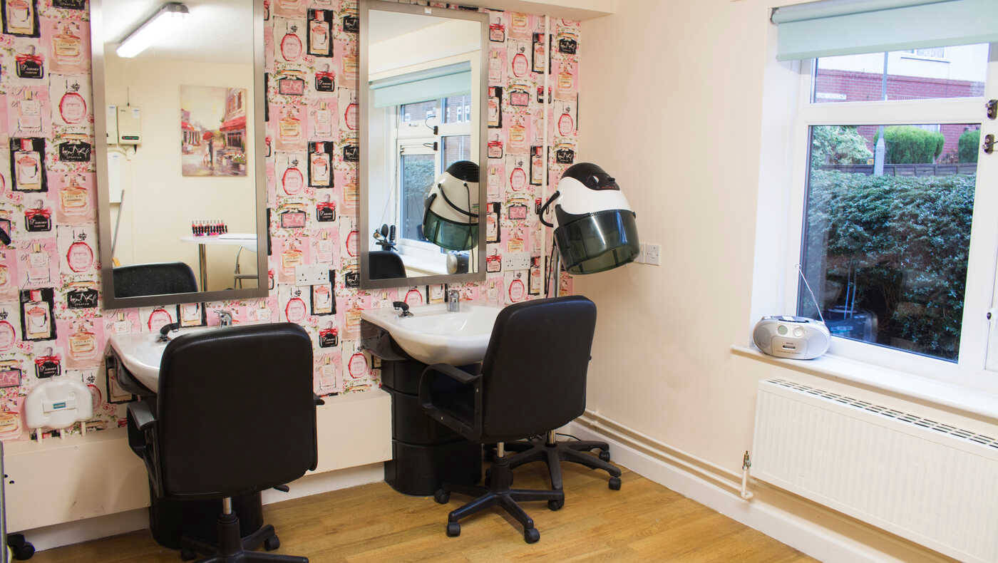 Hair salon area with styling chairs and mirrors